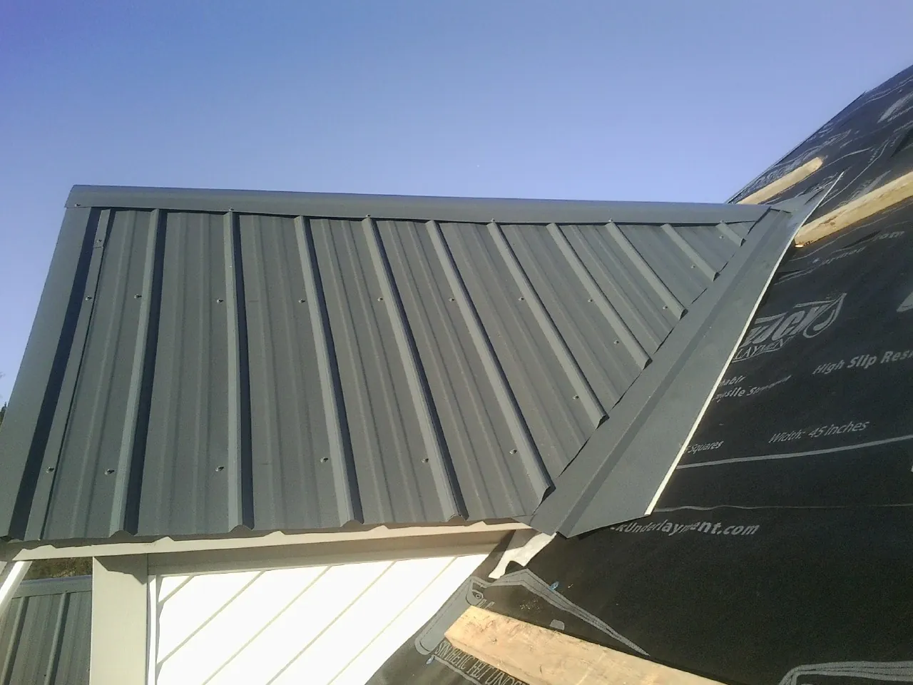 Gray metal roof panels going on over a garage gable in Ironton