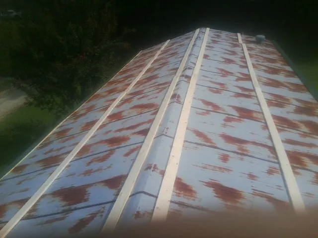 Rusted metal roof panels with new wood purlins before replacement — Storm Damage Roof Repair in Ironton by Roofing Brothers