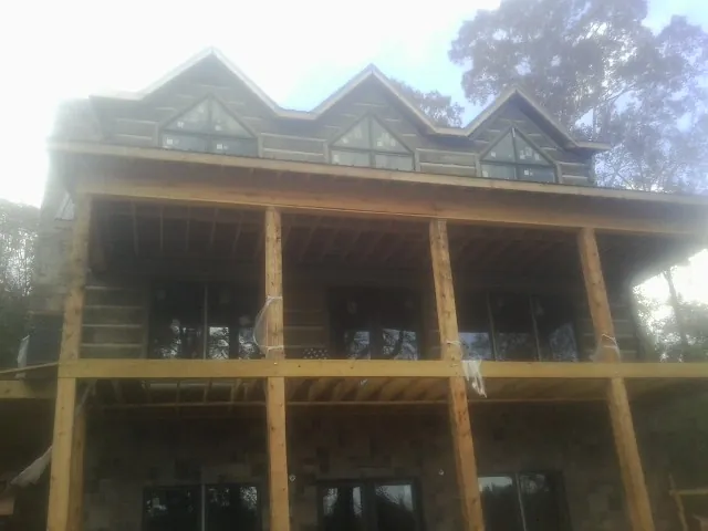 Dormers and porch framing on a large log home under construction — Roof Coating work by our crew in Ironton