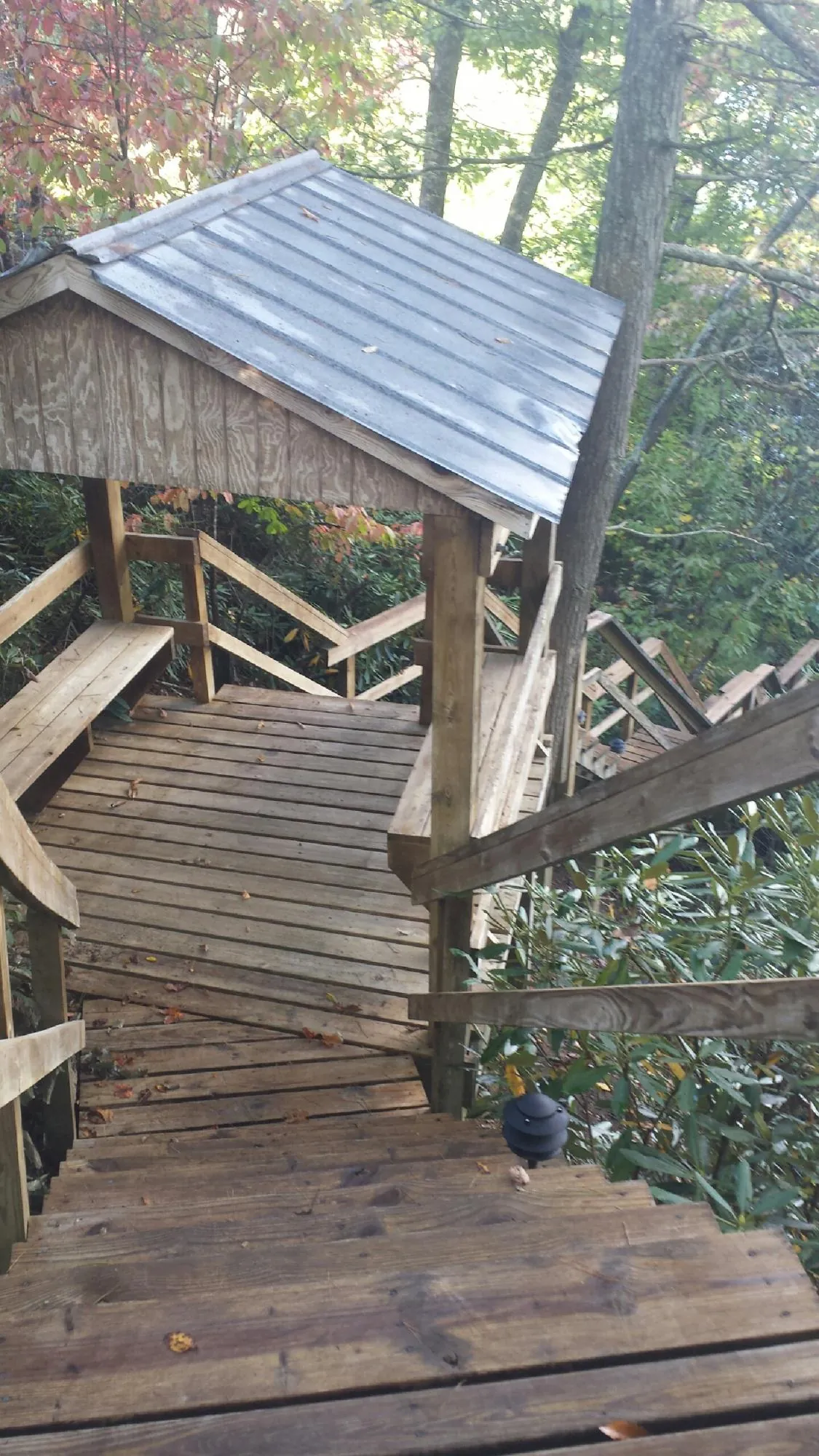 Metal roofed shelter over wooden steps on a wooded walkway — Skylight Repair & Installation work by our crew in Ironton