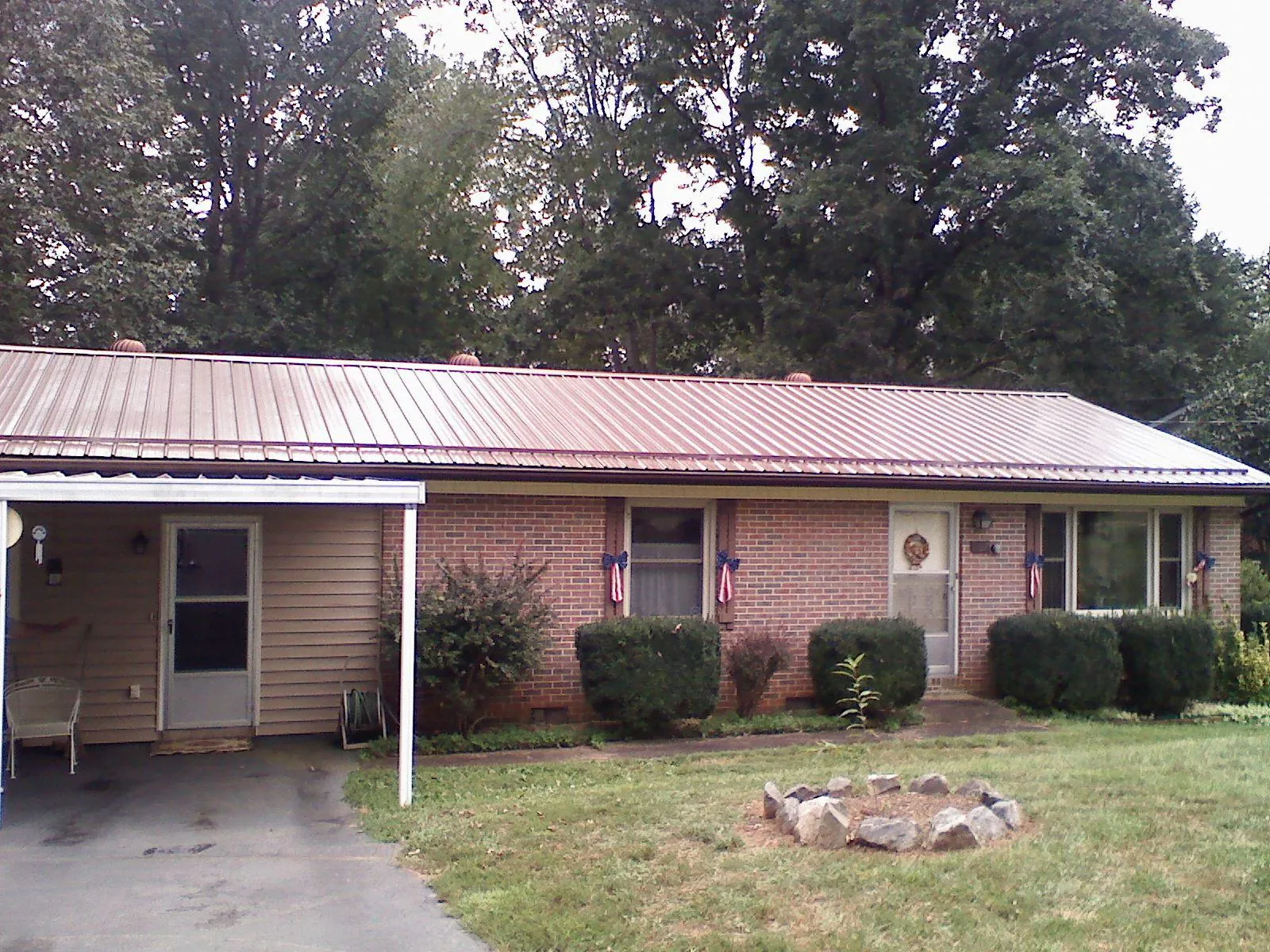 Bronze metal roof and carport on a brick ranch home — Roof Repair work by our crew in Ironton